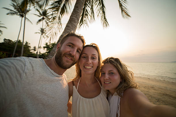 istock Happy young adults on tropical beach taking a selfie 465837704