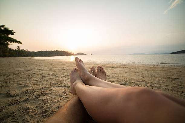 istock Couple's feet on tropical beach at sunset 465837712