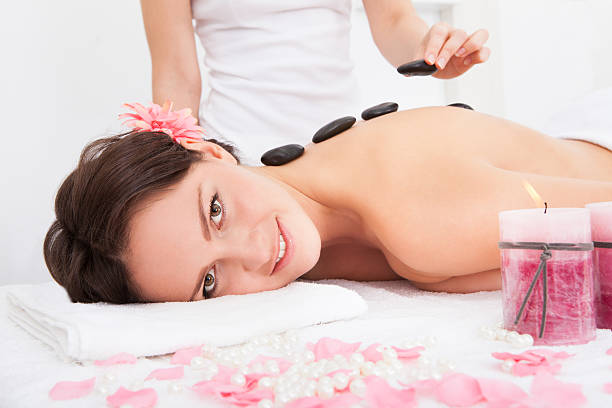 istock Person Placing Lastone On Woman's Back 465837773