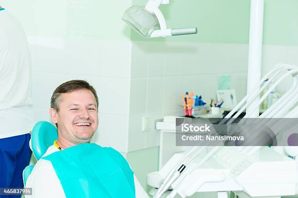 Smiling Patient Looking At Camera At The Dentist Office Stock Photo - Download Image Now