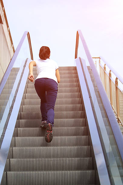 femme course sur l'escalator escaliers - railing beautiful human leg people photos et images de collection