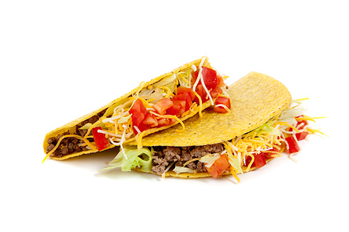 Two tacos on a white background with tomatoes, beef, lettuce and cheese