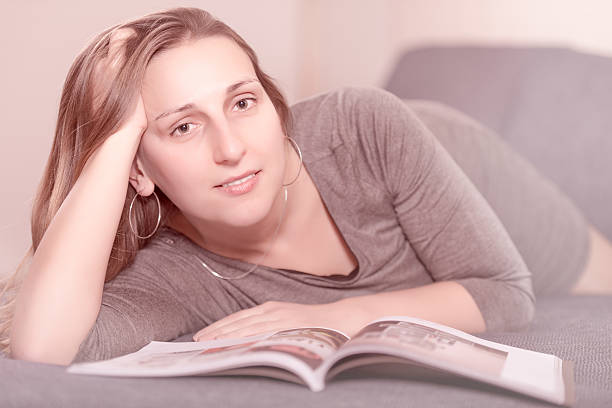 istock woman on the bed reading a magazine 465842978