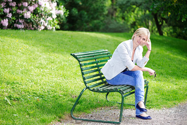 istock Handsome blond woman on bench looking at camera 465843300