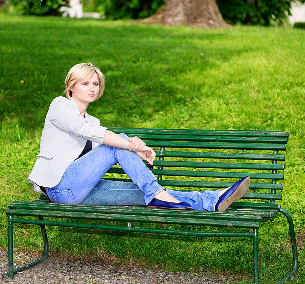 istock Handsome blond woman sitting on bench 465843452