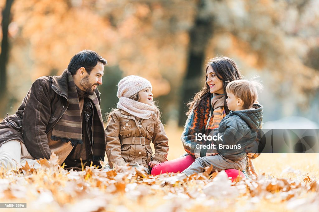 Family talking in autumn at the park. Happy family enjoying in autumn day in the park and talking. 2015 Stock Photo