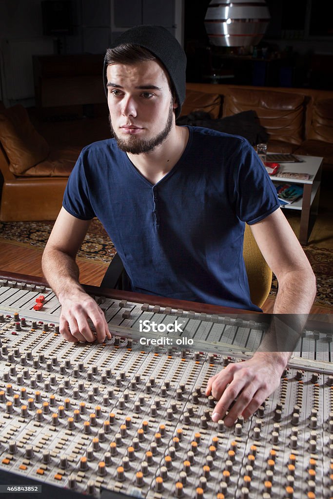 Hombre ingeniero de sonido con un estudio de mezcla escritorio - Foto de stock de Auriculares - Equipo de música libre de derechos