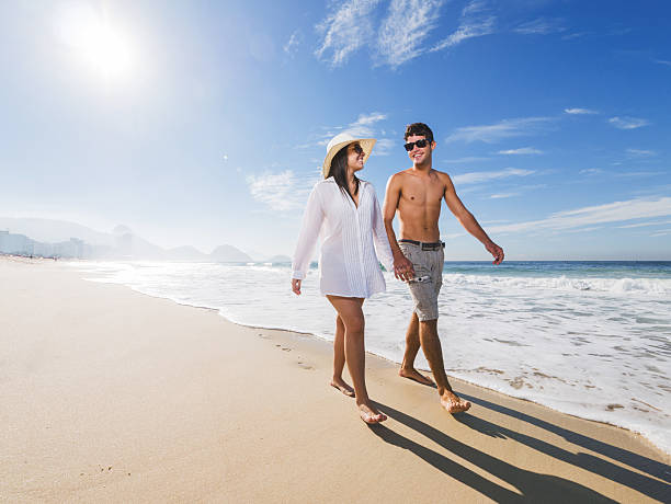 istock Young Hispanic couple walking on the beach. 465845060