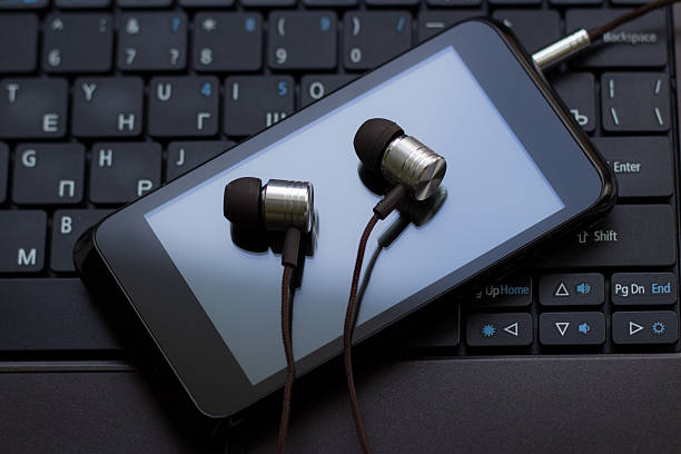 istock Headphones and  cell phone at the keyboard. 465846578