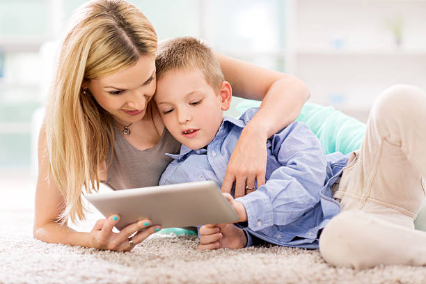 istock Mother and son using digital tablet on the carpet. 465847068
