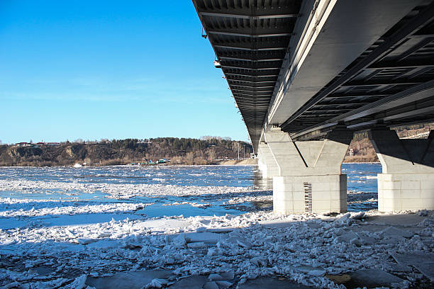 istock Bridge over the frozen river in sunny day. 465848642