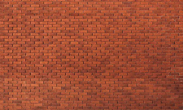 Modern red brick wall in gentle sunshine, full frame for texture use.