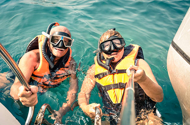 istock Senior happy couple using selfie stick in tropical sea excursion 465853572