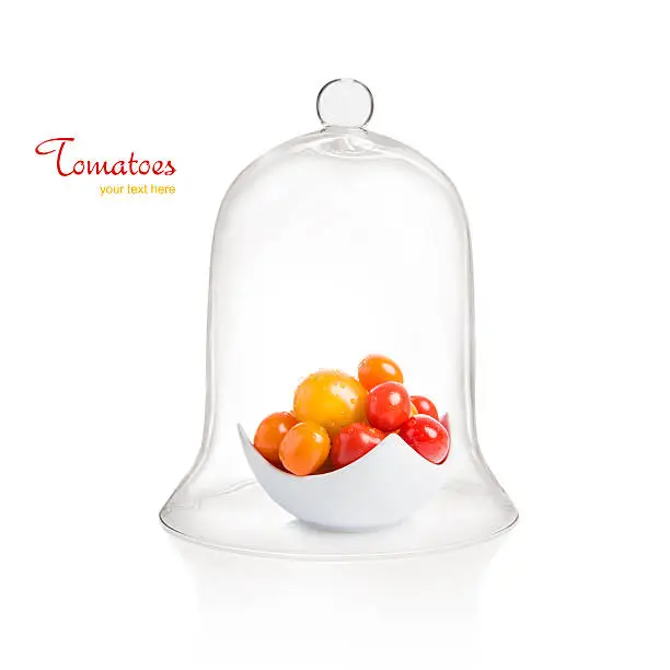 Tomatoes in bowl under bell jar