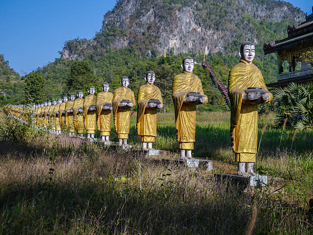 istock Statues of Buddhist monks walk collecting alms 465858402