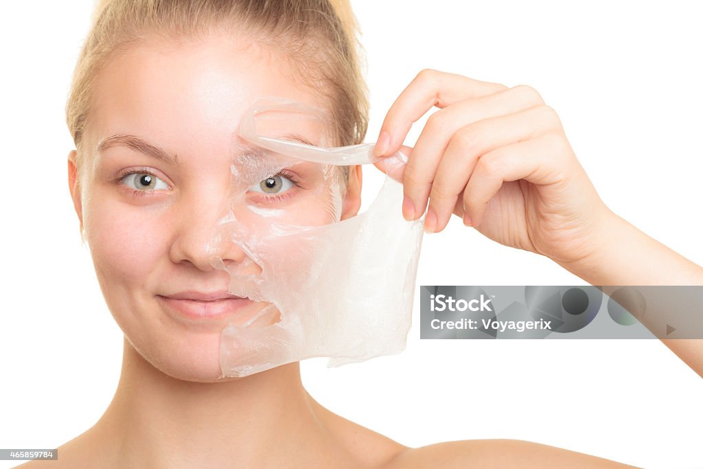 girl removing facial peel off mask Beauty skin care cosmetics and health concept. Closeup young woman face, girl removing facial peel off mask isolated on white. Peeling Peel - Plant Part Stock Photo