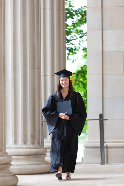 istock Happy Graduating Woman Student Walking on College Campus Vertical 465865623