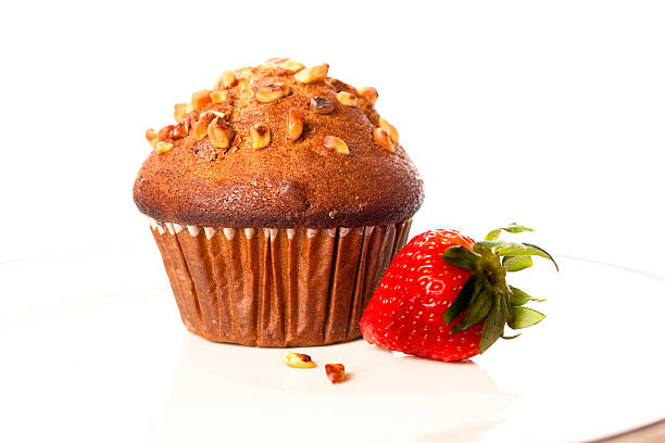 Healthy banana walnut, bran muffin with strawberry. Breakfast on white plate with white background. Nobody.
