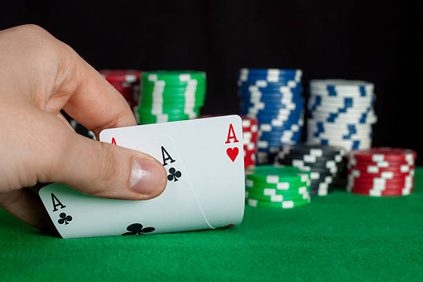 istock player checks his hand, two aces in, focus on card 465878783