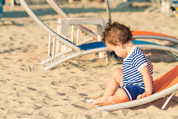 istock Toddler dressed as sailor sitting on a tilted sunbed 465884178