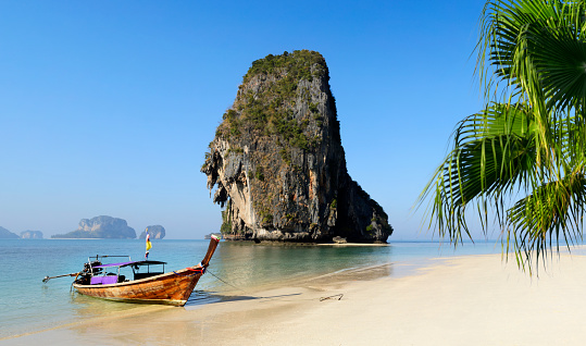 Longtail boat moored on the sand on Railay beach in Thailand.