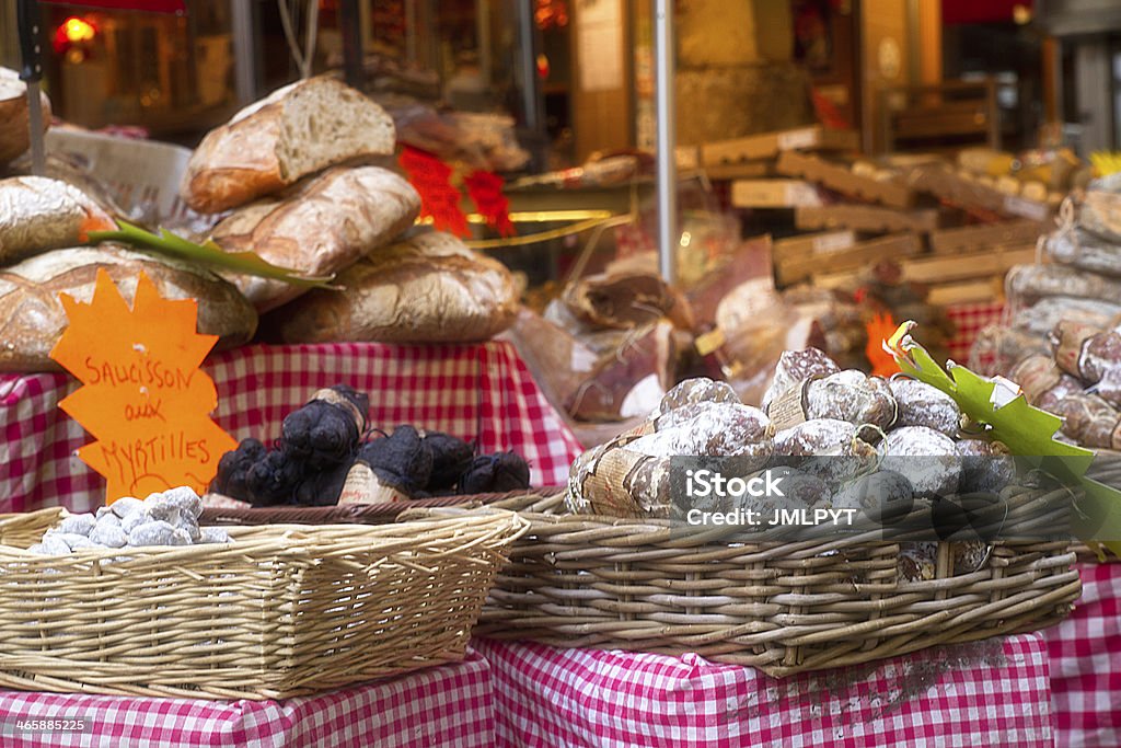 Stall of delicatessen on a market in Paris Stall of delicatessen on a market in Paris. On the orange label it is written that the sausage is made with blueberries. Convenience Store Stock Photo