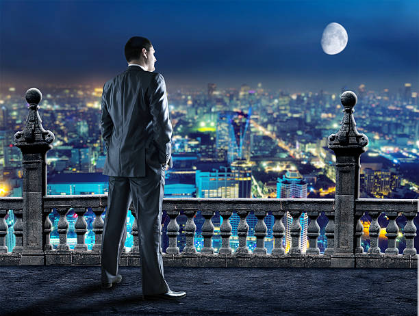 istock Businessman looks at the evening town 465885302