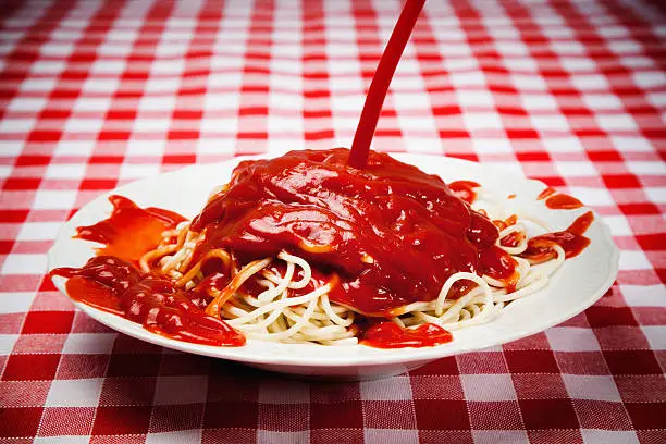 pouring too much tomato ketchup on spaghetti pasta