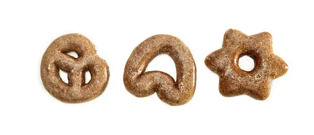 Three separate gingerbread of different shapes coated with icing sugar on light background