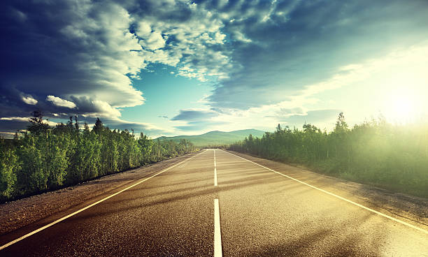 istock Single lane tarred road heading straight ahead to mountains 465898250