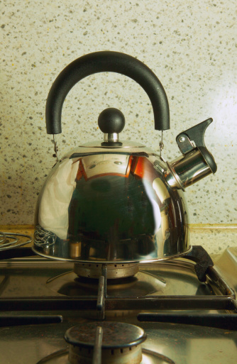 A Metal kettle over stove, entire view