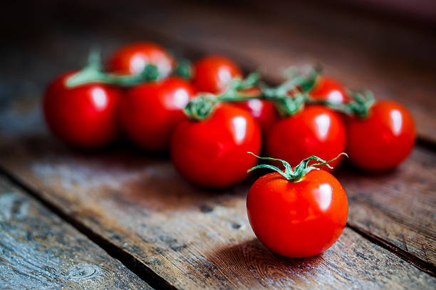 istock Tomatoes on the vine at rustic wooden background 465903017