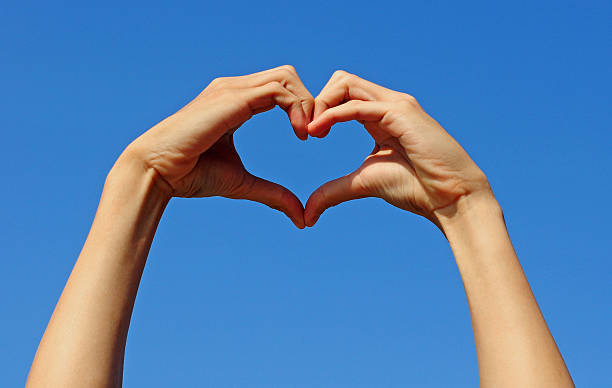 istock Hand making the sign of love with blue sky background 465904401