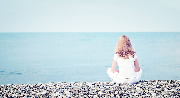 istock sad lonely  young beautiful woman sitting back on beach 465904727