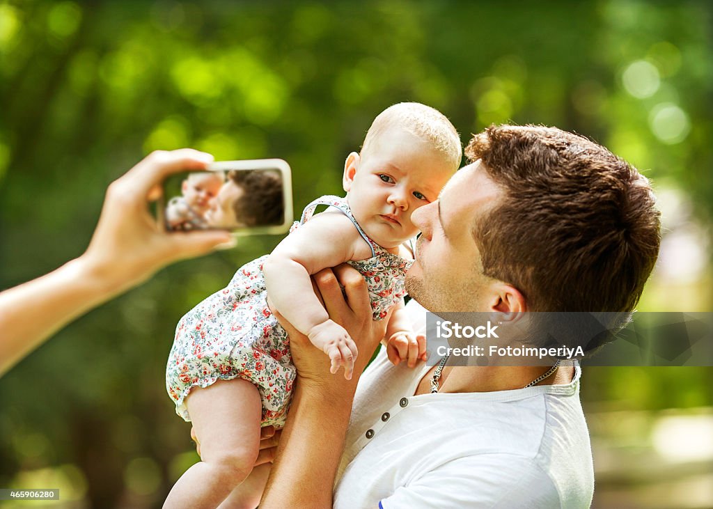 happy family having fun in the park parents with baby in park 2015 Stock Photo