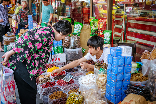 Bangkok, Thailand - December 19, 2014: Street vendor selling sweets and spices at a stall in Bangkok's Chinatown.
