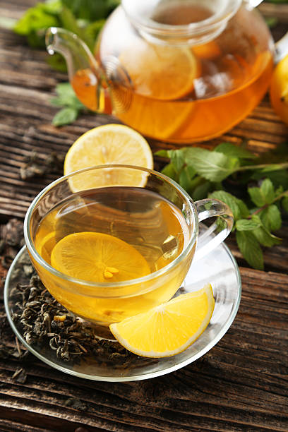 istock Cup with green tea and teapot on brown wooden background 465910410