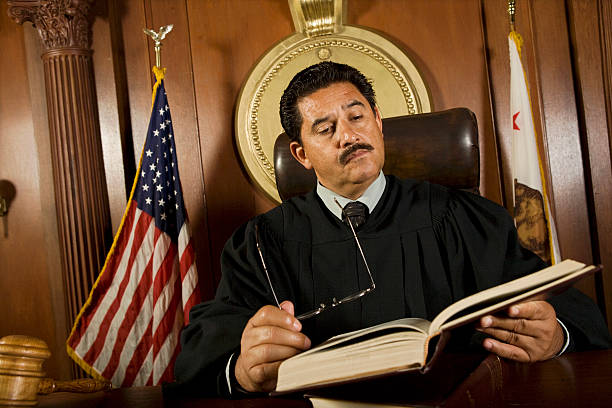 Courtroom Judge reading in court middle eastern ethnicity mature adult book reading stock pictures, royalty-free photos & images