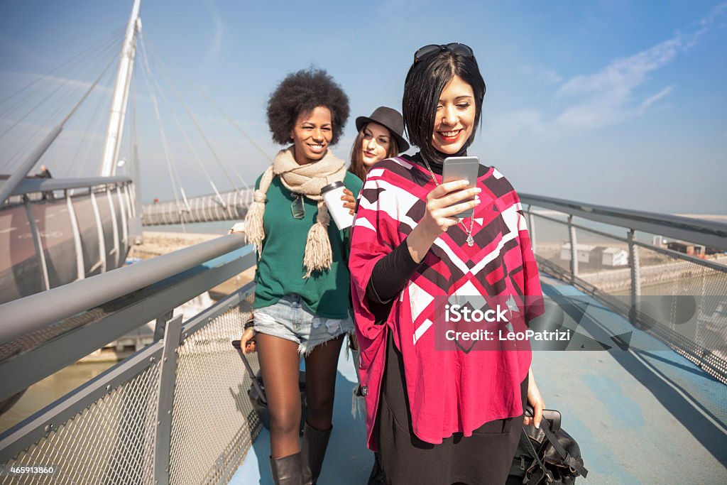 Women friends right outside the airport walking to the exit Women friends right outside the airport walking to the exit for directions and transportation for the city center 2015 Stock Photo