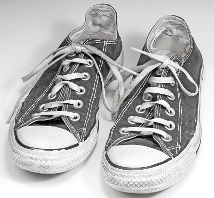 pair of black canvas sneakers on white background