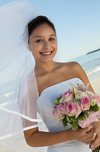 istock Happy Bride Holding Flower Bouquet On Beach 465921523