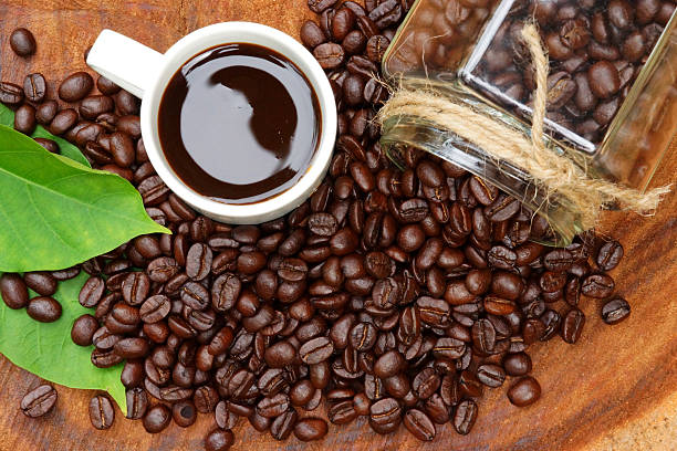 istock Roasted coffee beans on wood and black coffee. 465922373