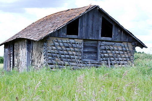 Old abandoned log shed in countryside