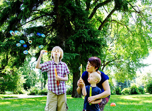 garçon bulles de soufflage - bubble wand outdoors little boys mother photos et images de collection