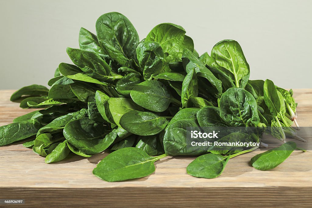 Fresh Spinach Fresh Spinach composition with sun shining on wood table Backgrounds Stock Photo
