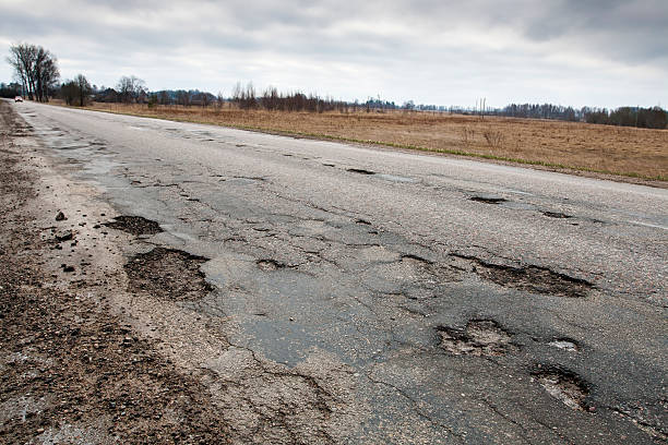 Damaged road Badly damaged country asphalt road after winter run down stock pictures, royalty-free photos & images
