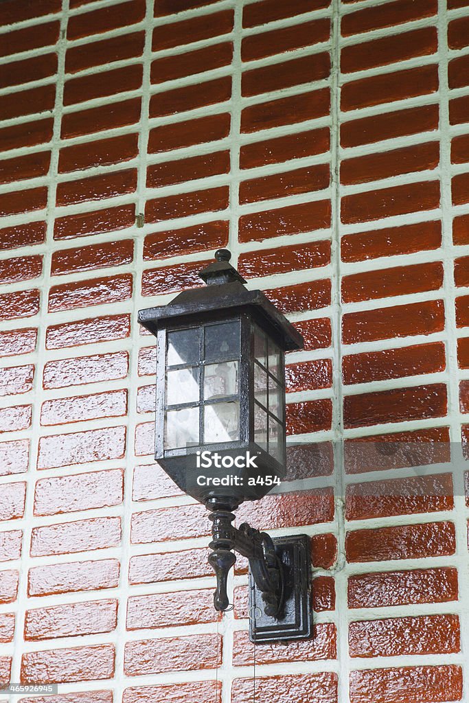 Lamp on the wall. Lamp on the wall. Home painted red brick wall with black lamp. Architecture Stock Photo