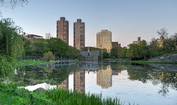 Harlem Meer, Central Park, New York Harlem Meer Lake in Central Park, New York and the reflections of nearby buildings. harlem park stock pictures, royalty-free photos & images