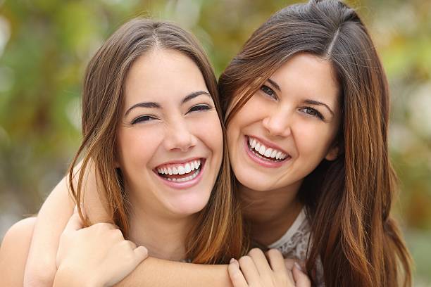 istock Two women friends laughing with a perfect white teeth 465932760