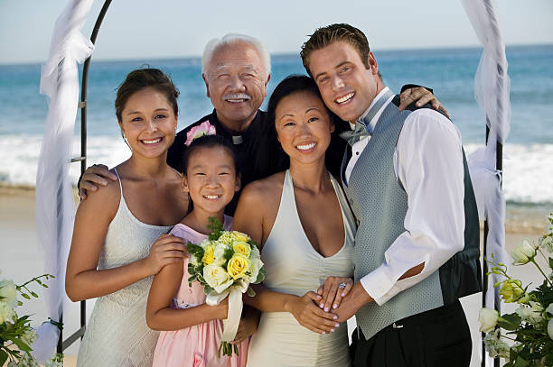 Bride And Groom With Family At Beach Portrait of a bride and groom with family at the beach wedding bride hugging father on wedding day stock pictures, royalty-free photos & images